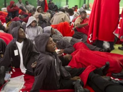Inmigrantes descansan dentro de un centro deportivo en Tarifa, este martes.