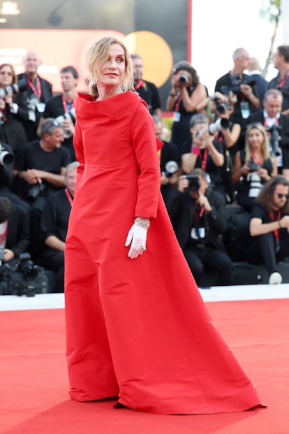 Atrevido, pero clásico. El estilista de toda la vida de la actriz, Jonathan Huguet, ha descrito así en 'Vogue' la elección del vestido-abrigo de ópera rojo perteneciente a la primera colección de alta costura de Balenciaga de Demna, que llevó Huppert en la apertura del festival: para él, evocaba la imagen de las divas de los años 50 que frecuentaban el teatro. Realizado en un vivo “rojo papa italiano”, y combinado de guantes blancos hasta el codo y joyas de Cartier, se acompañaba de un toque relajado, divertido y rompedor como son unas gafas de sol negras de aspecto futurista. 