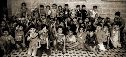 Hikmat Shaihan, de 26 años, posa, este año, junto a los niños del colegio que dirige en Alepo oriental.