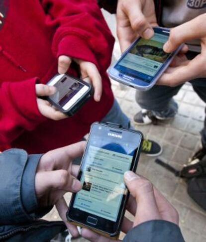 Tres joves es connecten a la xarxa amb els seus ‘telèfons intel·ligents’.