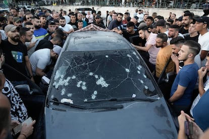 Una multitud rodea el coche atacado por fuerzas israelíes en Nablus (Cisjordania) este miércoles.