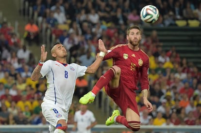 O chileno Arturo Vidal disputa a bola com o espanhol Sergio Ramos.