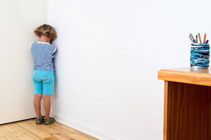 Un niño está castigado contra la pared.