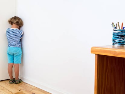 Un niño está castigado contra la pared. 