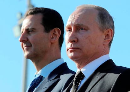 El presidente ruso, Vladímir Putin, y el presidente sirio, Bashar Assad, observan el desfile de tropas en la base aérea de Hemeimeem en Siria tras declarar la victoria en Siria, el lunes 11 de diciembre de 2017.