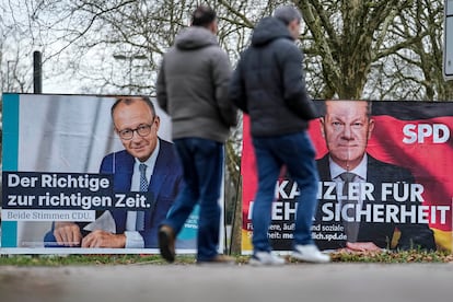 Dos personas pasan frente a los carteles electorales de los dos principales candidatos en las elecciones de Alemania, el 11 de febrero en Düsseldorf.