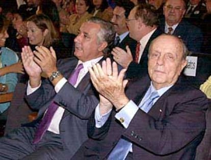 Javier Arenas y Manuel Fraga aplauden durante el mitin de ayer en Santiago.