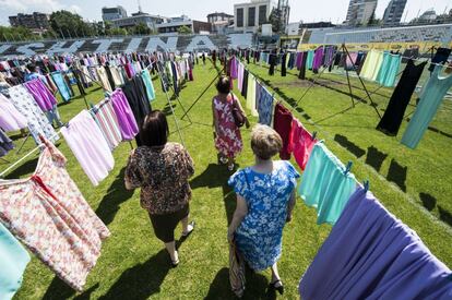 La instalación se titula "Thinking of You", en recuerdo a las mujeres que fueron víctimas de violencias sexuales durante la guerra de Kosovo entre los años 1998 y 1999. En la imagen, tres mujeres caminan entre dos tendederos.