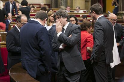 El presidente de la Generalitat de Cataluña, Carles Puigdemont (centro), conversa con el vicepresidente, Oriol Junqueras.