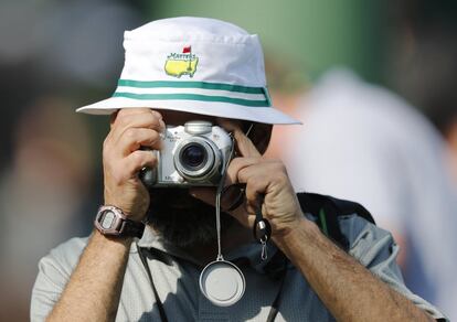 Un asistente toma fotografías durante los entrenamientos del Masters de Augusta, el 2 de abril de 2018.





