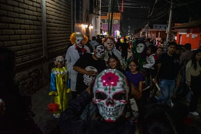 Una familia posa junto a una escultura en forma de cráneo, en Ocotepec. 