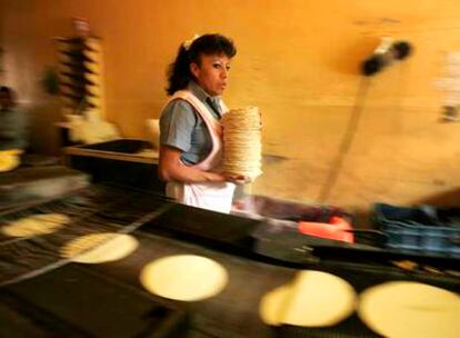 Una trabajadora recoge tortillas recién horneadas en una tienda de la ciudad de México.