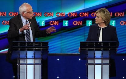 Hillary Clinton escucha a Bernie Sanders durante el debate demócrata.