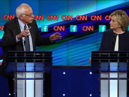 Hillary Clinton escucha a Bernie Sanders durante el debate demócrata.