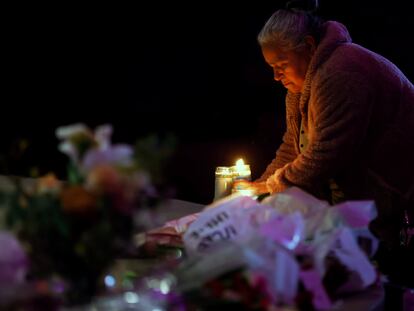 Merced Martinez places a candle at a memorial for victims of the mass shooting the day before in Half Moon Bay, Calif., Tuesday, Jan. 24, 2023.