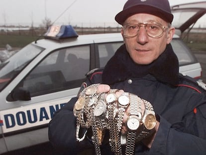 Un funcionario de aduanas muestra falsificaciones de relojes Rolex y Cartier.
