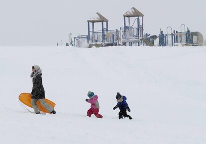 Una mujer y dos niños disfrutan de la nieve en Portland, Maine (Estados Unidos).