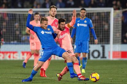 Messi lucha el balón con Ignasi Miquel.