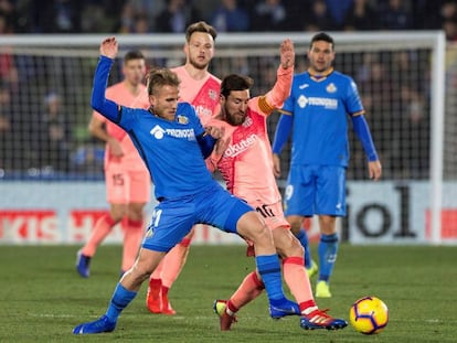 Messi lucha el balón con Ignasi Miquel.