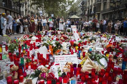 Turista y barceloneses frente a un altar improvisado en Las Ramblas de Barcelona, en homenaje a las víctimas del atentado.
