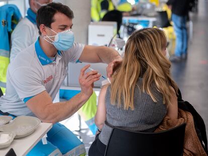 Un enfermero inocula una dosis de la vacuna a una mujer en Madrid.