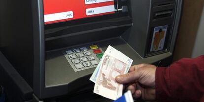 Un hombre retira euros de un cajero automático.