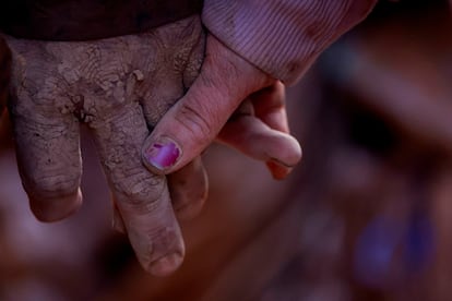 Eva Defez, de 50 años, sujeta la mano de su marido, Enrique Fernández, manchadas de barro tras el paso de la dana en Utiel, este miércoles.