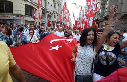 Un grupo de manifestantes porta una bandera turca de lanzan cánticos de camino a la plaza de Taksim.