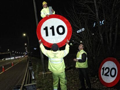 Operarios cambiando las señalas de las autovías y autopistas en 2011.