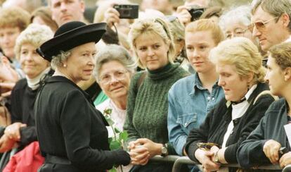 La reina Isabel de Inglaterra saluda a los ciudadanos que hacen cola ante el palacio de St James, en Londres, para firmar en el libro de condolencias por la muerte de la princesa Diana De Gales.