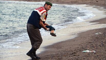 Un policía traslada el cadáver de un niño en una playa de Turquía.