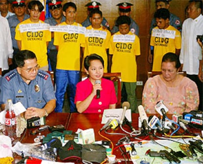 Macapagal Arroyo, durante la rueda de prensa, con los detenidos al fondo.