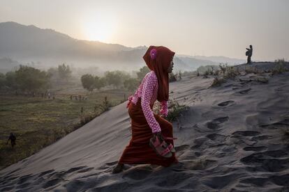 Una joven camina por las dunas de la playa Parangkusumo en Yogyakarta, Indonesia.