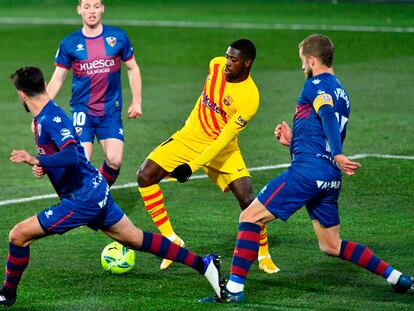 Ousmane Dembélé busca un pase rodeado de defensores del Huesca.