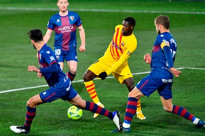 Ousmane Dembélé busca un pase rodeado de defensores del Huesca.