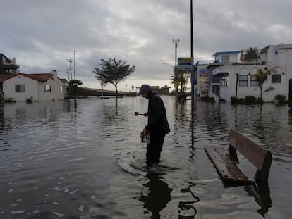 Un residente camina por una calle inundada, después de que las tormentas azotaran el norte de California, en la ciudad costera de Aptos, el 5 de enero de 2023.