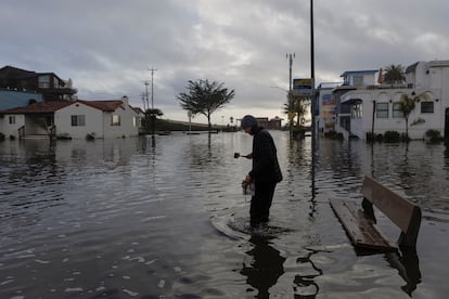 Un residente camina por una calle inundada, después de que las tormentas azotaran el norte de California, en la ciudad costera de Aptos, el 5 de enero de 2023.