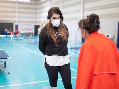 Begoña Arana habla con una mujer alojada en el pabellón para sin techo instalado en Algeciras.