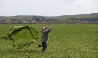 Un niño juega con una tienda de campaña como cometa en el campo de refugiados provisional de Idomeni, en la frontera entre Grecia y Macedonia.