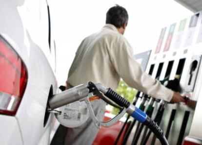 Un hombre reposta en una gasolinera.