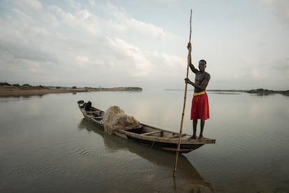 Los pescadores nómadas suelen vivir en comunidades vulnerables con acceso limitado a recursos e infraestructuras. Los fenómenos meteorológicos extremos, como las tormentas e inundaciones, pueden aumentar aún más su fragilidad financiera, provocando la pérdida de artes de pesca, daños en las embarcaciones y el desplazamiento de sus caladeros tradicionales. En la foto, tomada en febrero de 2023, se ve a Yaheya, un pescador nómada Igala de 25 años, al amanecer en el río Níger.  