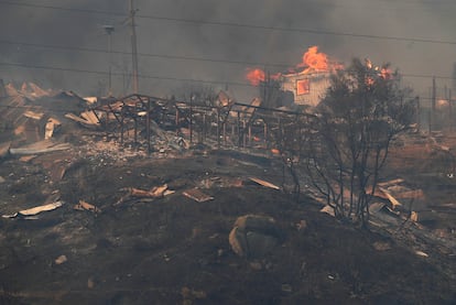 Una casa se quema en medio de una zona arrasada por el fuego, el 3 de febrero.