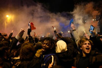 Aficionados franceses junto al Arco del Triunfo en la avenida de los Campos Elíseos tras llegar Francia a la final del mundial de Qatar.