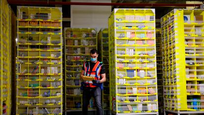 Un empleado de mantenimiento de Amazon revisa el inventario en un almacén de Brétigny-sur-Orge (Francia), el 14 de diciembre de 2021.