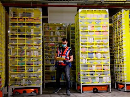 A maintenance worker goes over inventory in an Amazon warehouse in Brétigny-sur-Orge, France, on December 14, 2021