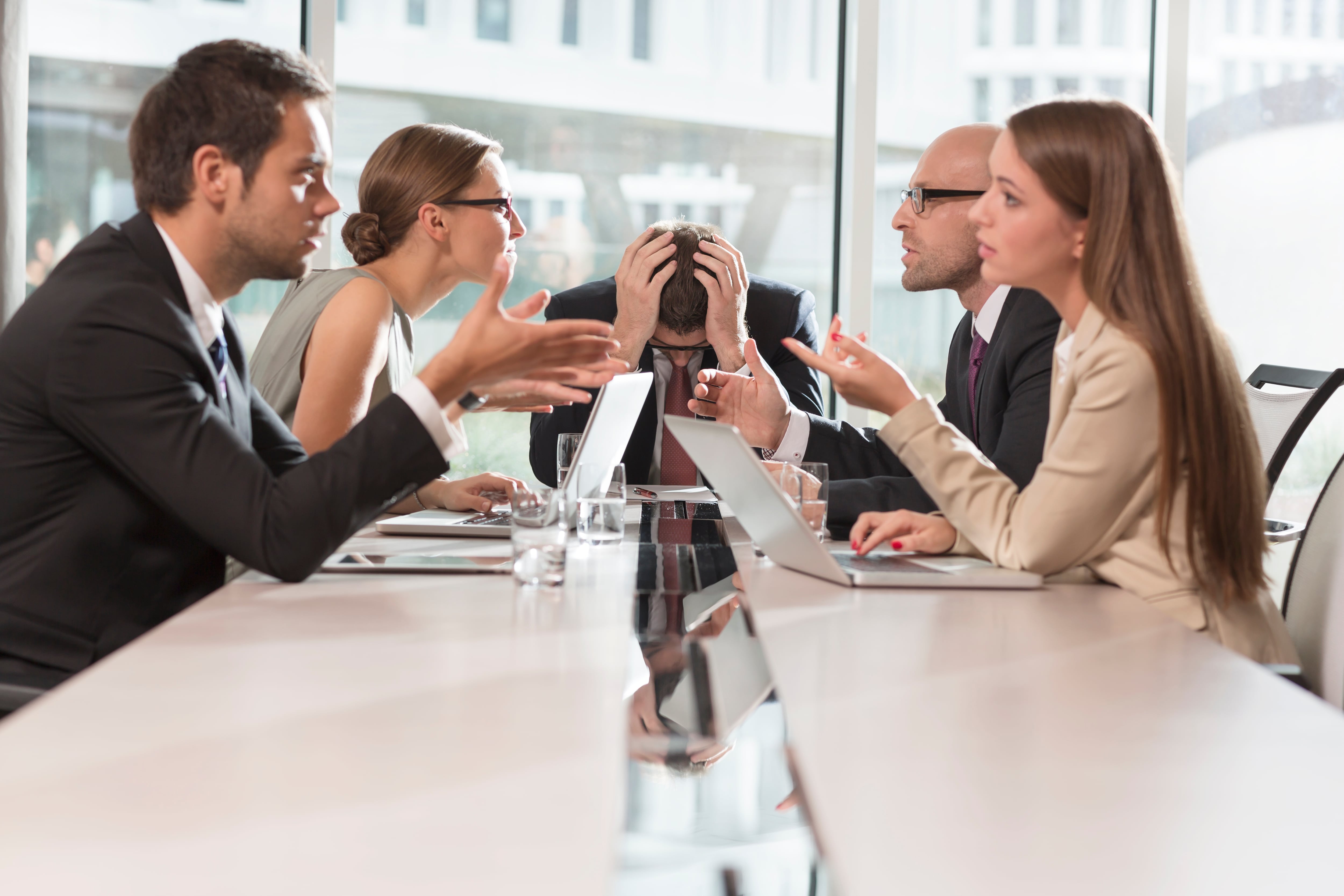 Varios empleados discuten en una mesa de reuniones. 