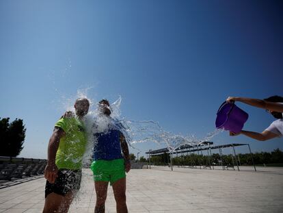 Varias personas se refrescan este jueves en el parque Juan Carlos I de Madrid.