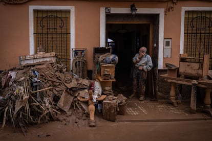 Un hombre habla por telfono junto a las pertenencias que ha logrado sacar del bajo de una vivienda inundada en el centro de Paiporta, provincia de Valencia, el jueves 31 de octubre de 2024.