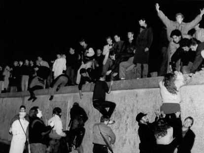 El 10 de noviembre de 1989, un grupo de jóvenes ayudan a otros a escalar el muro de Berlín.