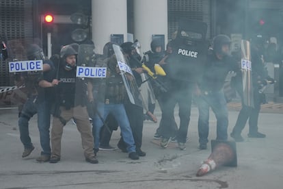 Agentes con escudos protectores se colocaron hombro con hombro para bloquear la entrada al edificio.